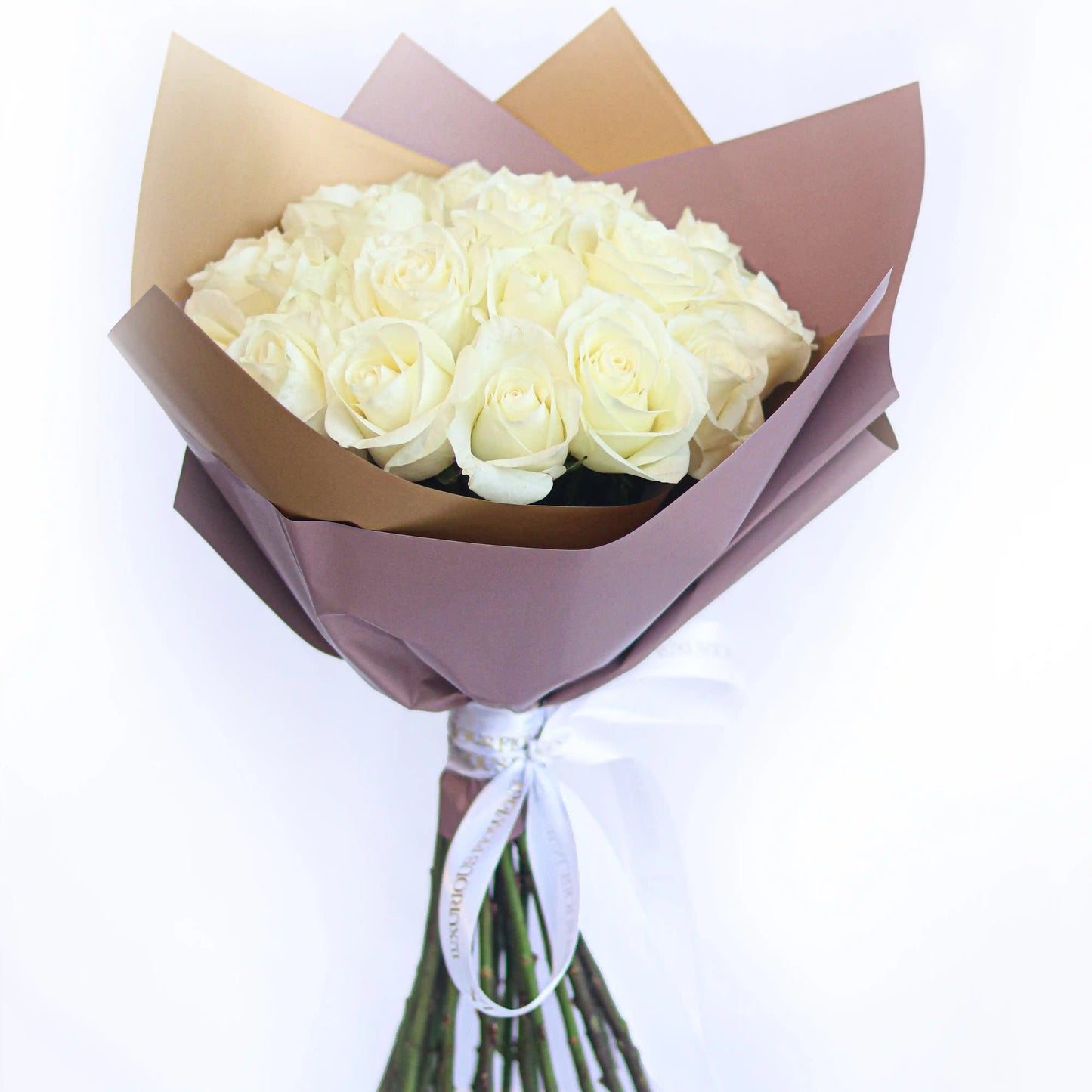 Bouquet of white roses wrapped in brown paper with a white ribbon on a light gray background