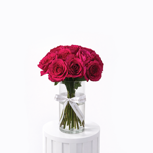 25 fuchsia roses arranged in a clear glass vase for sale in Dubai with delivery