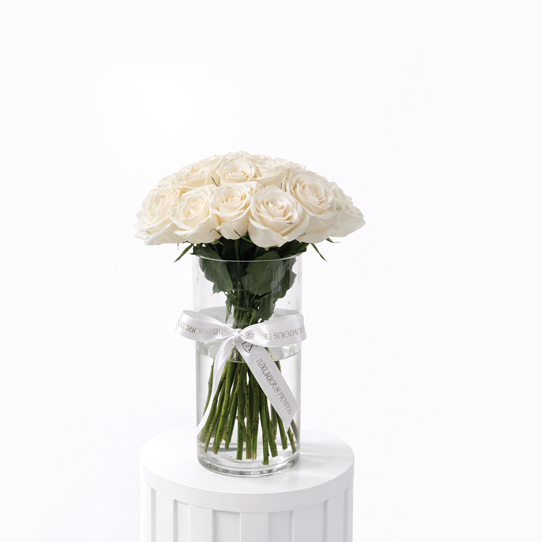 25 white roses arranged in a clear glass vase for sale in Dubai with same day delivery