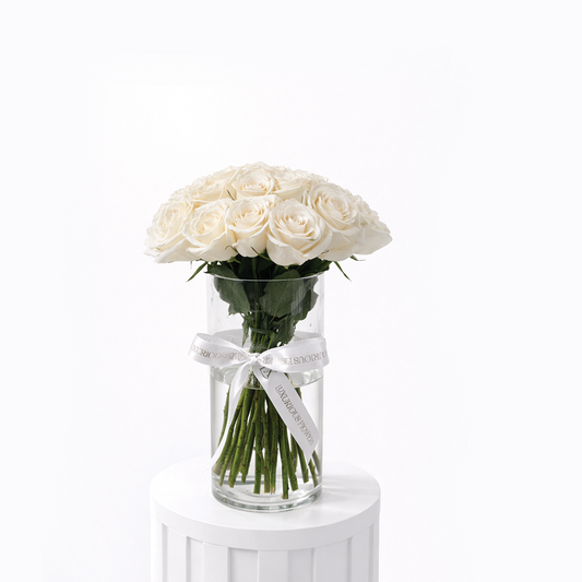 25 white roses arranged in a clear glass vase for sale in Dubai with same day delivery