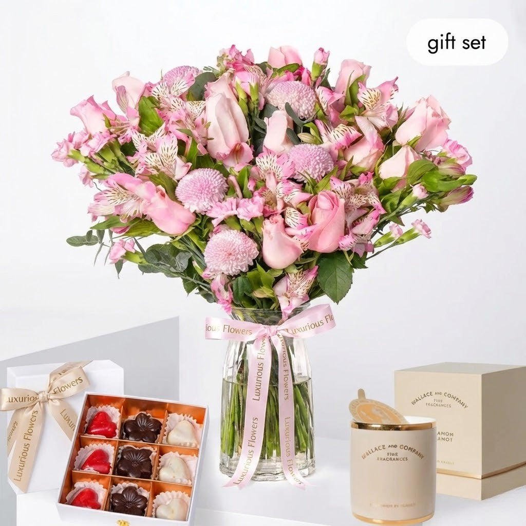 Bouquet of pink flowers with a box of chocolates and a candle on a white background