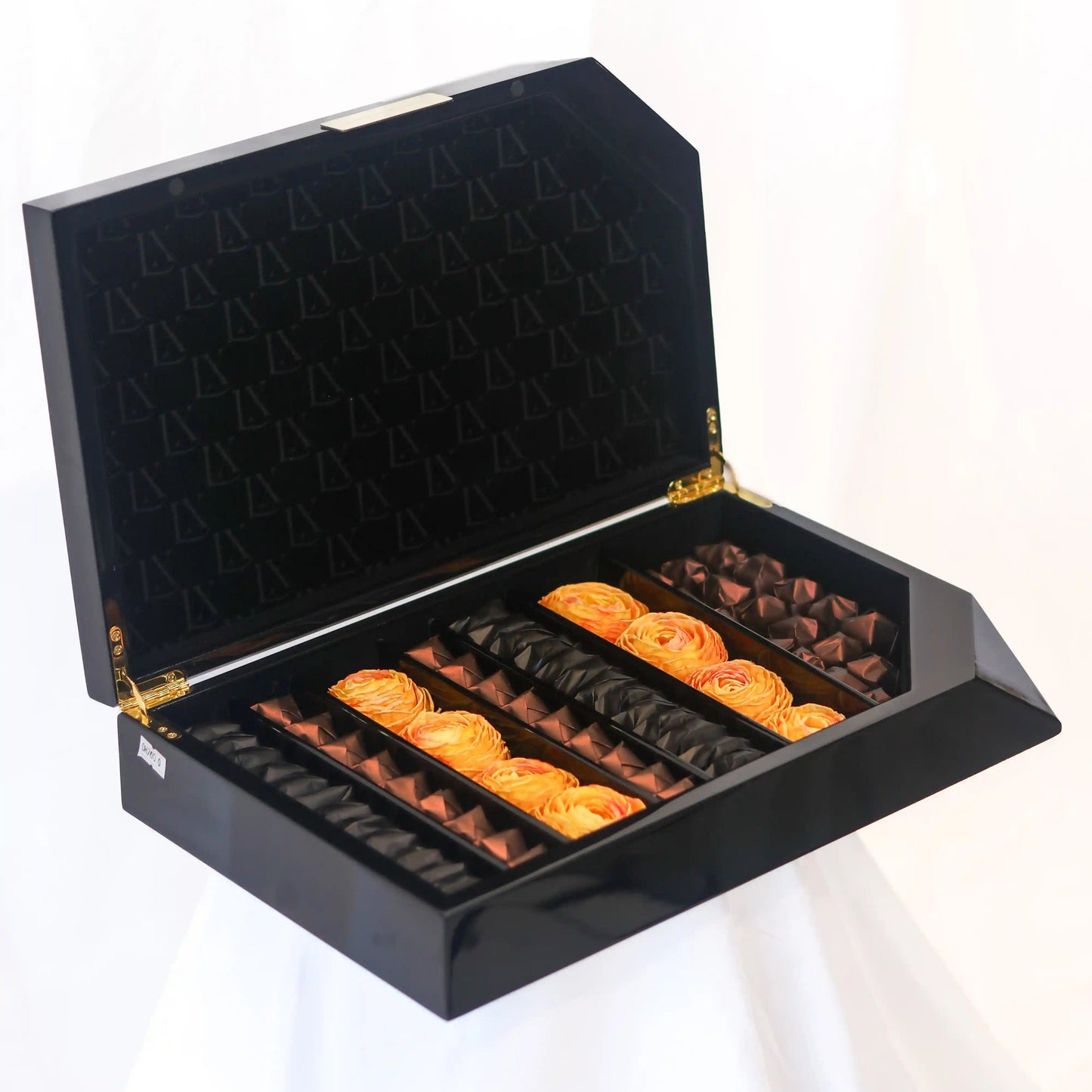 Black chocolates box with gold accents containing flowers for special for sale inn dubai 