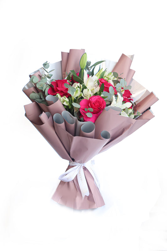 Bouquet of flowers wrapped in brown paper with a white ribbon on a white background
