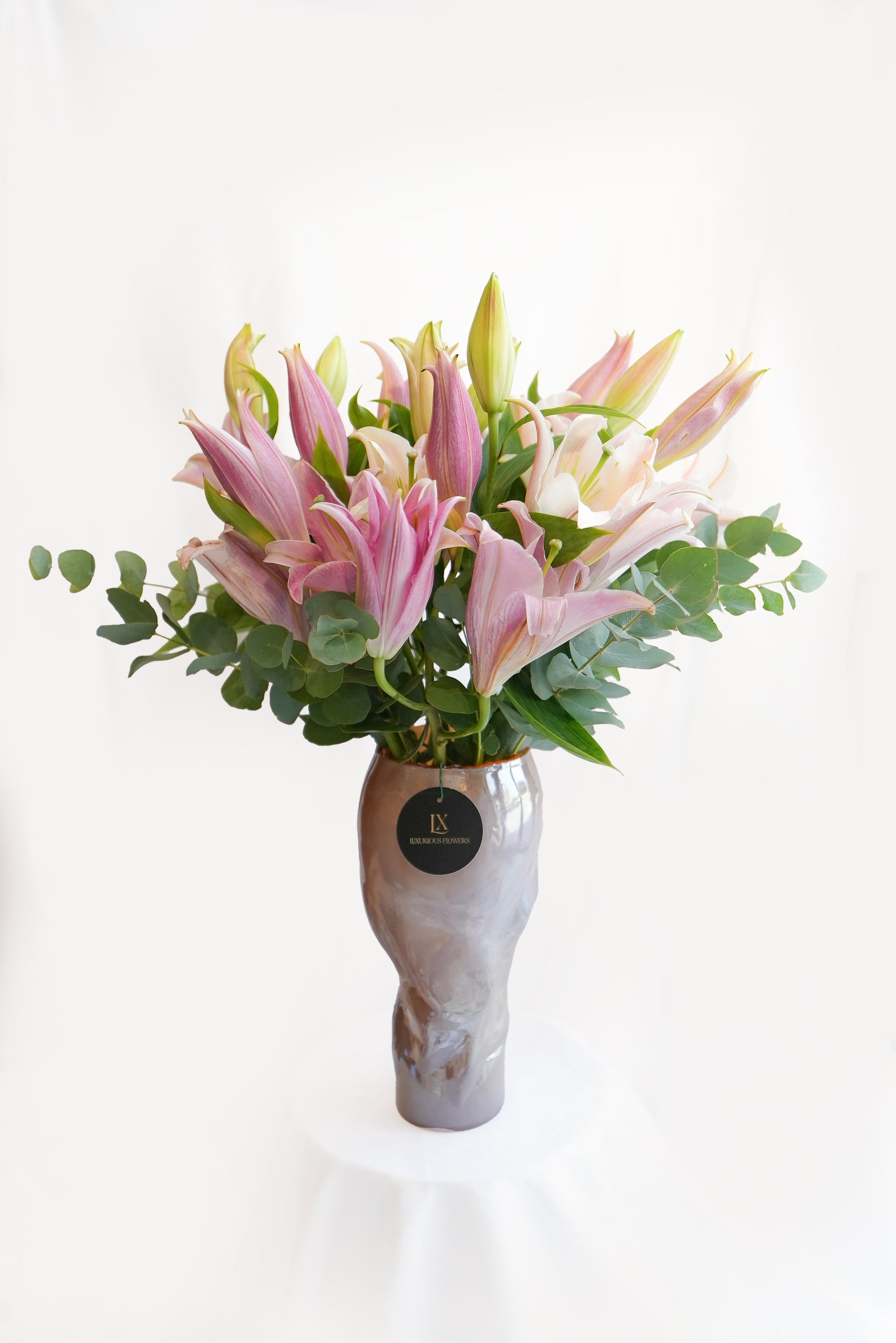 Bouquet of pink and white flowers in a gray vase on a white background