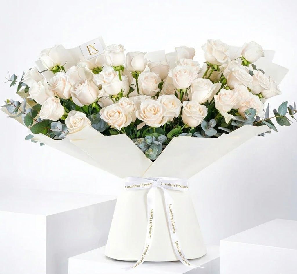 Bouquet of white roses in a white box with a visible brand name on a white background