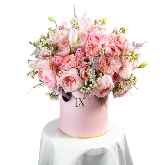 Pink floral arrangement in a matching pink box with 'LX' logo on a white background