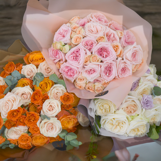 Three colorful bouquets of roses held together with a blurred background
