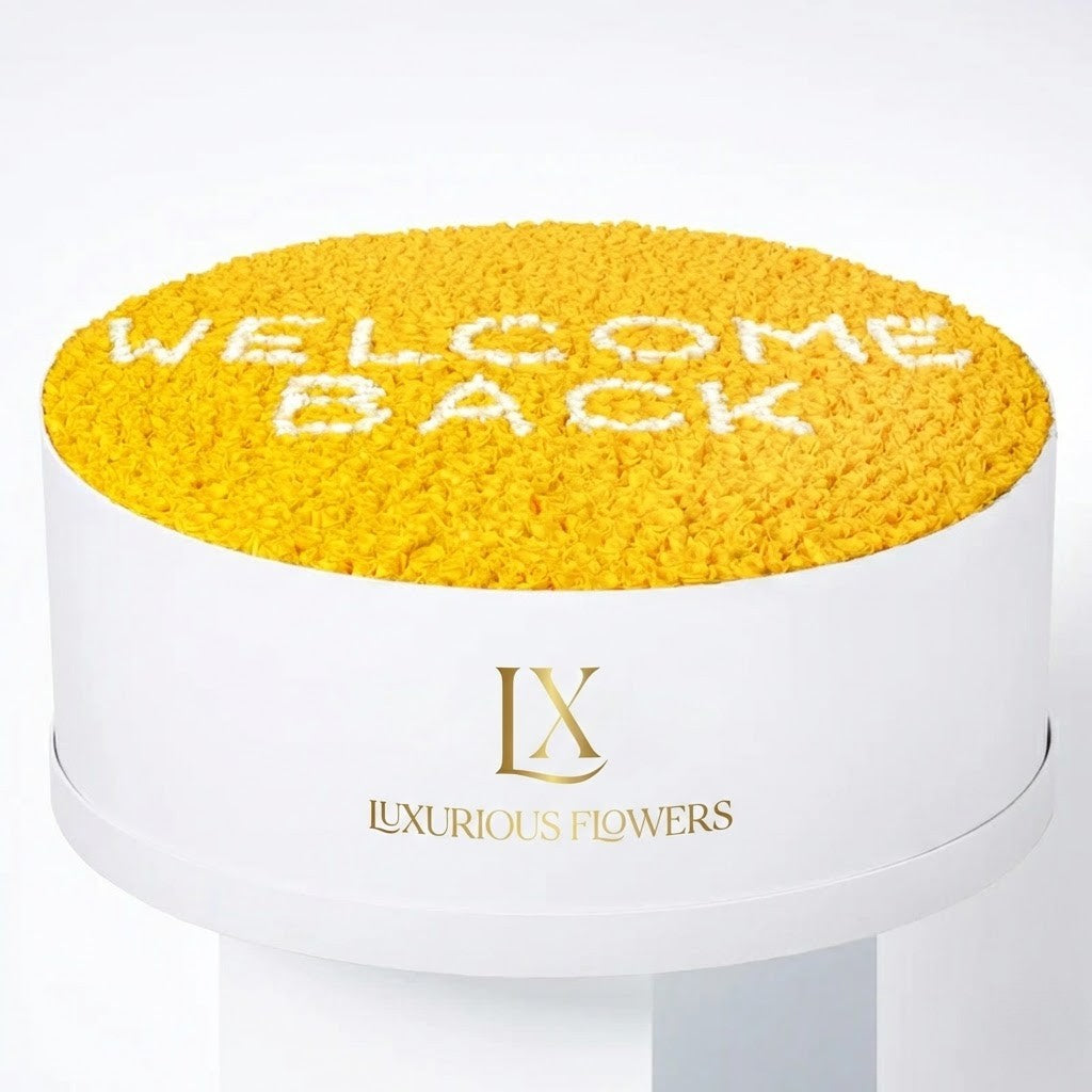 Yellow flower arrangement with 'Welcome Back' text on a white background, featuring the Luxurious Flowers logo.