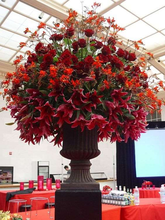 An urn of red roses, lilies, and Crocosmia montbretia - Luxurious Flowerssimple