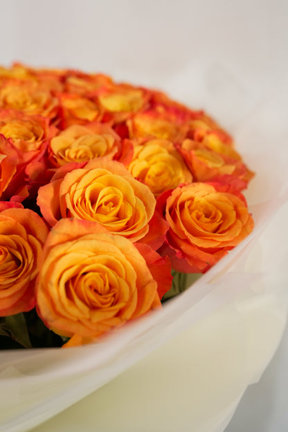 Large arrangement of vibrant fresh orange roses in designer wrapping for sale in Dubai