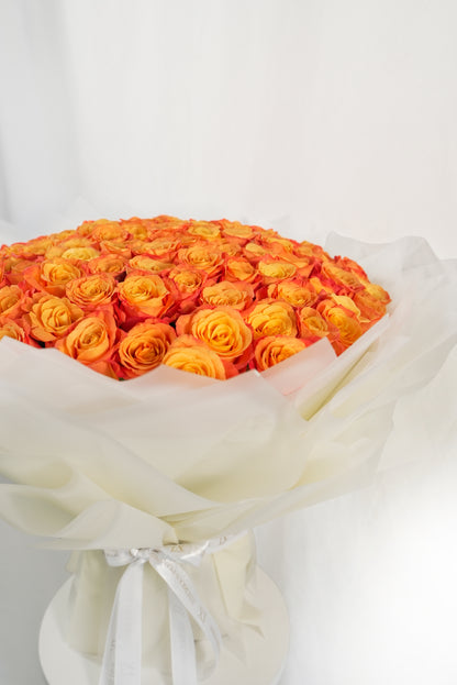 Large arrangement of vibrant fresh orange roses in designer wrapping