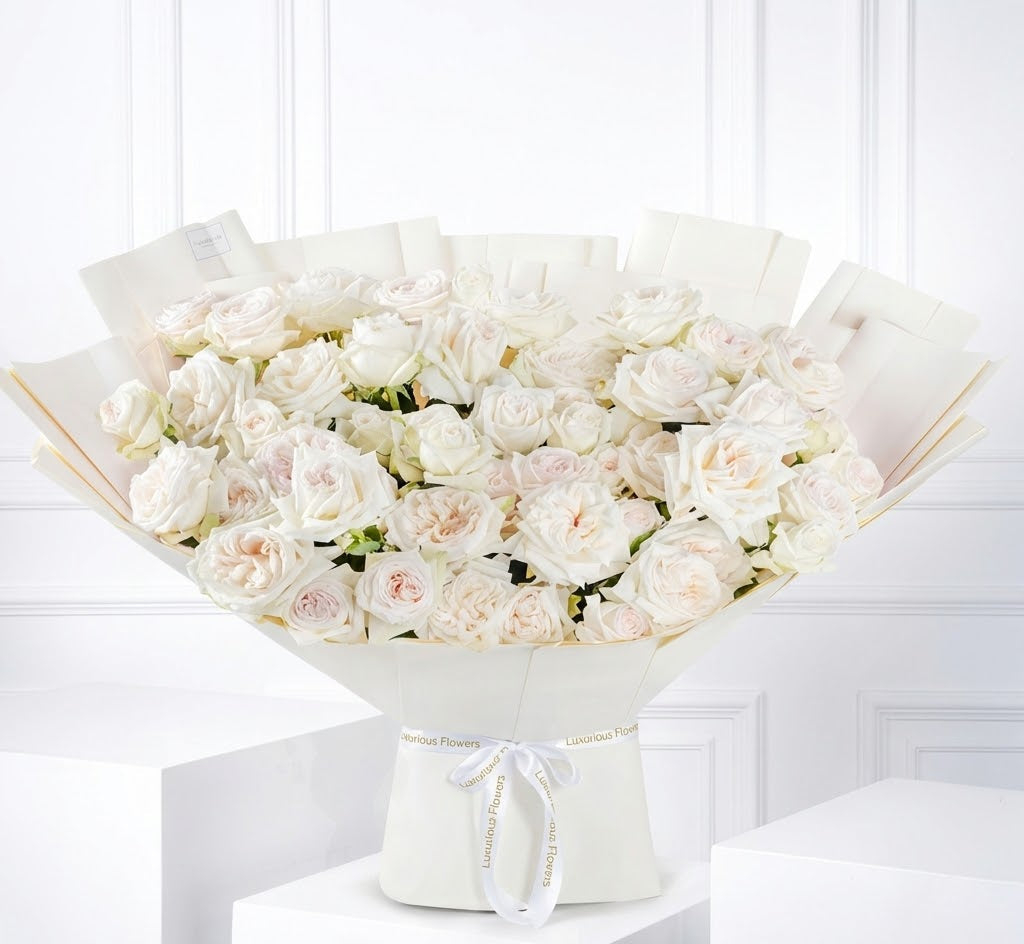 Bouquet of white flowers in a white box on a white surface with a white background