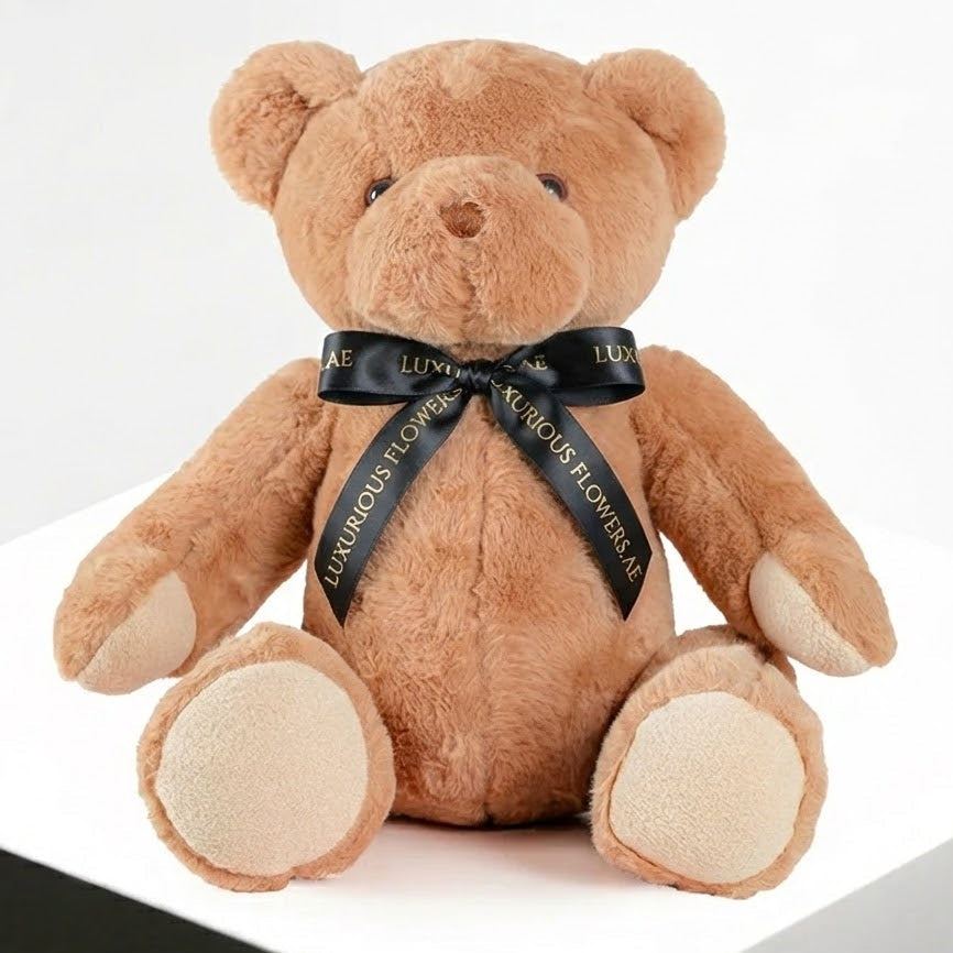 Brown teddy bear with a black ribbon on a white background