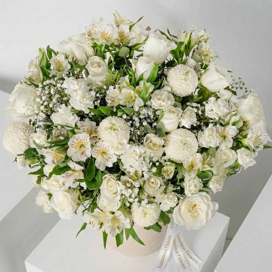 Bouquet of white flowers in a white vase on a light gray background