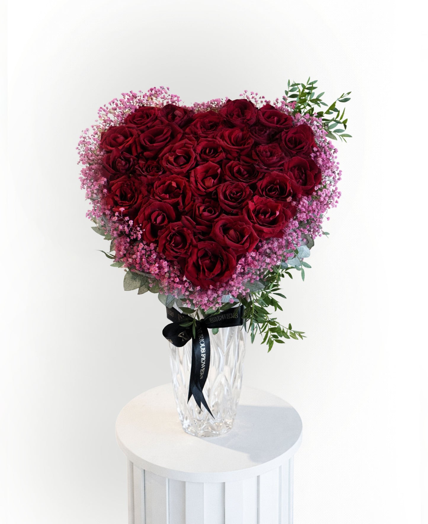 Heart-shaped red roses in crystal vase with pink accents – Luxury Valentine flower arrangement in Dubai